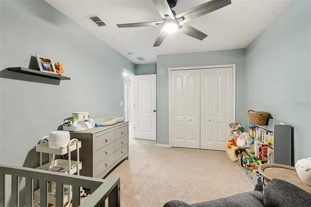 a bedroom with furniture and a chandelier fan