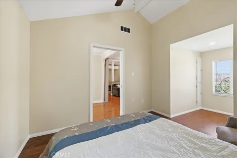 a bedroom with a bed and painting on the wall