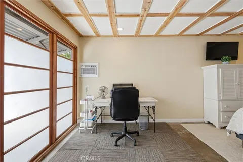 a view of a workspace with furniture and a window