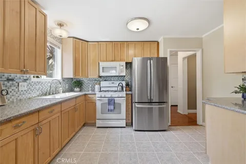 a kitchen with stainless steel appliances granite countertop a refrigerator and a sink