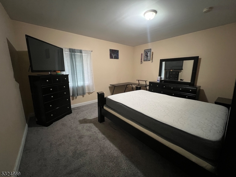 692 East 26th Street, Unit 1 Paterson, NJ 07504 - Photo 4 of 6 a bedroom with a bed and a flat screen tv