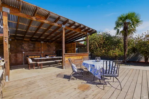 a view of a patio with a table and chairs under an umbrella with wooden floor