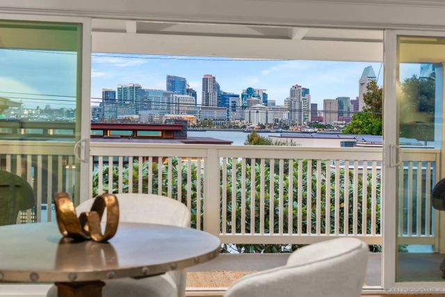 a view of a city from a balcony with chairs