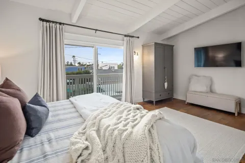 a bedroom with a large bed and a flat screen tv