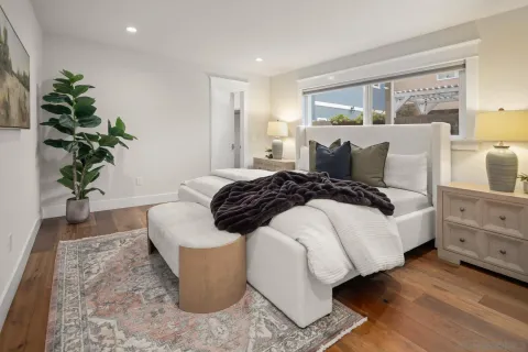 a bedroom with a large bed and a potted plant