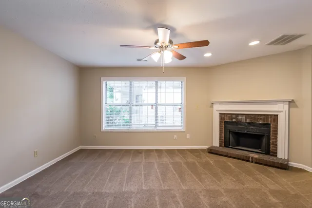 an empty room with fireplace and windows