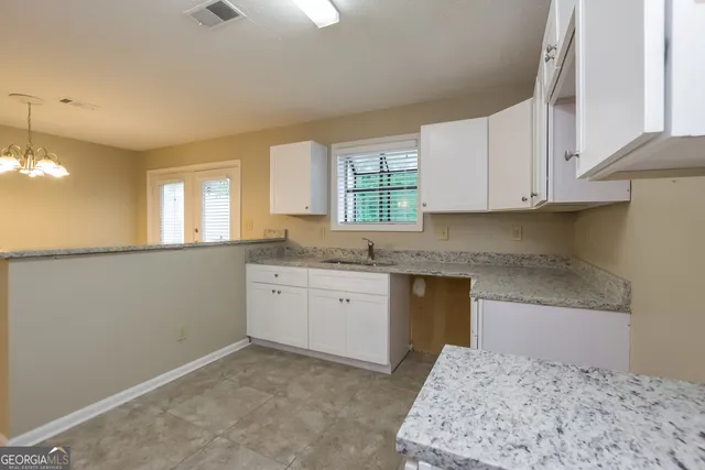 a kitchen with granite countertop cabinets stainless steel appliances a sink and a window