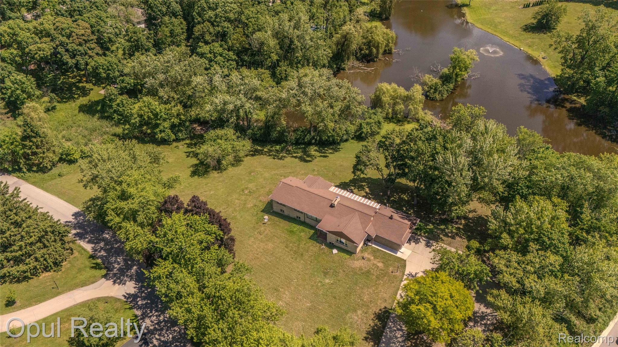 6455 Norham Road Bloomfield Hills, MI 48301 - Photo 88 of 93 Property with expansive green space, mature trees, and a private pond featuring a fountain