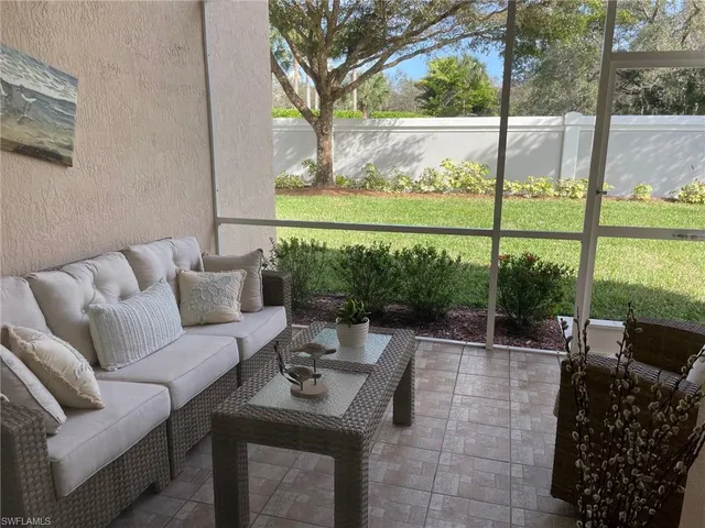 a living room with patio furniture and a garden