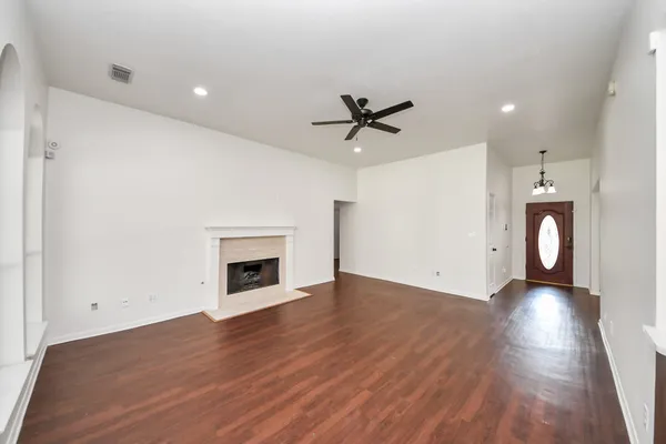 a view of an empty room with a fireplace and a window