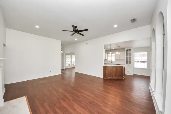 a view of an empty room with a window and wooden floor