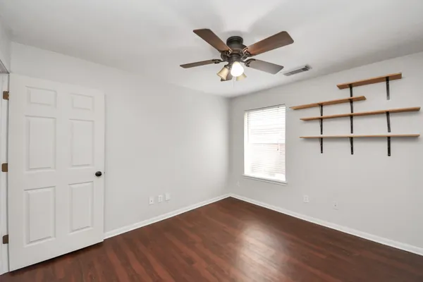 a view of a big room with wooden floor closet and windows