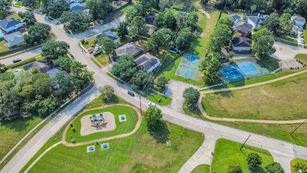 an aerial view of a swimming pool with a yard and plants