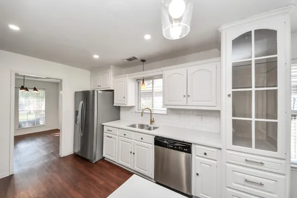 a kitchen with stainless steel appliances a refrigerator sink and cabinets