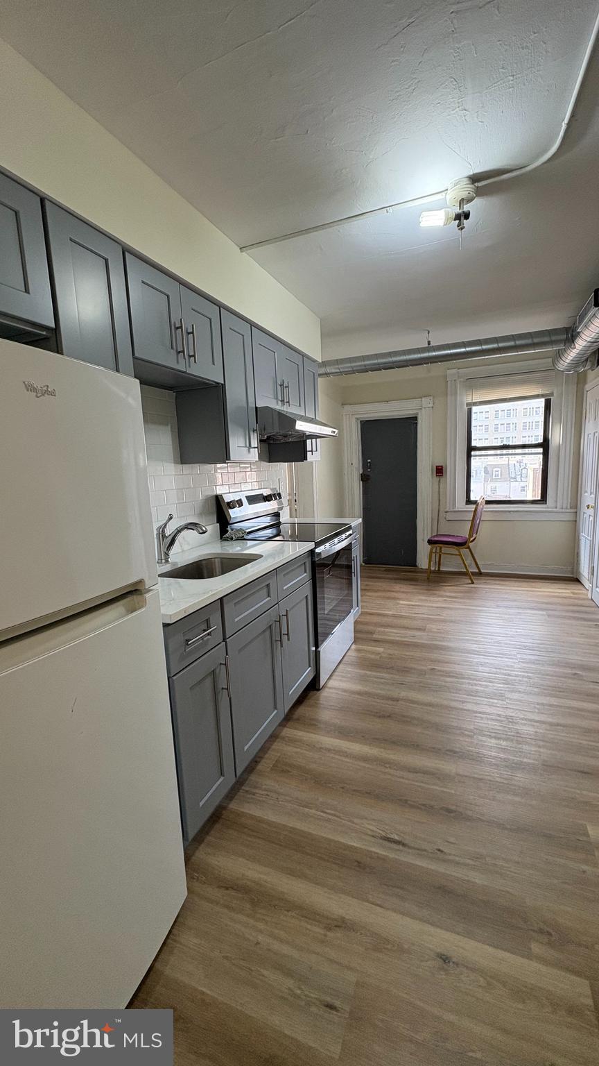 228 North 10th Street, Unit 4F Philadelphia, PA 19107 - Photo 7 of 9 a kitchen with kitchen island a sink stainless steel appliances and cabinets