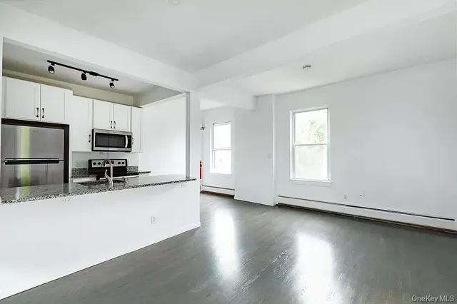 a kitchen with stainless steel appliances a microwave a sink and a refrigerator