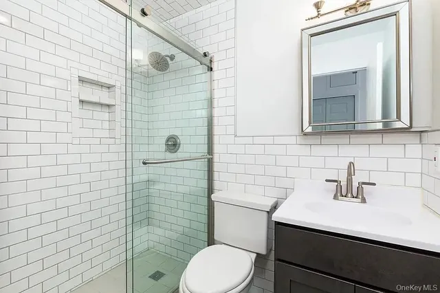 a bathroom with a sink a toilet and mirror