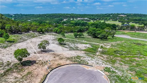 an aerial view of a house with a yard and lake view
