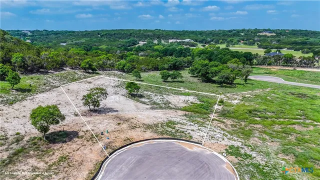 an aerial view of a house with a yard and lake view