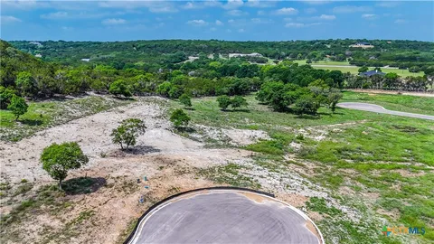 an aerial view of a house with a yard and lake view