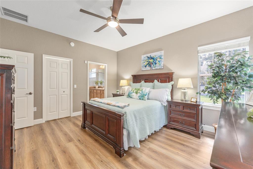 19639 Southwest 77th Loop Dunnellon, FL 34432 - Photo 31 of 59 a bedroom with a large bed a chandelier and a window