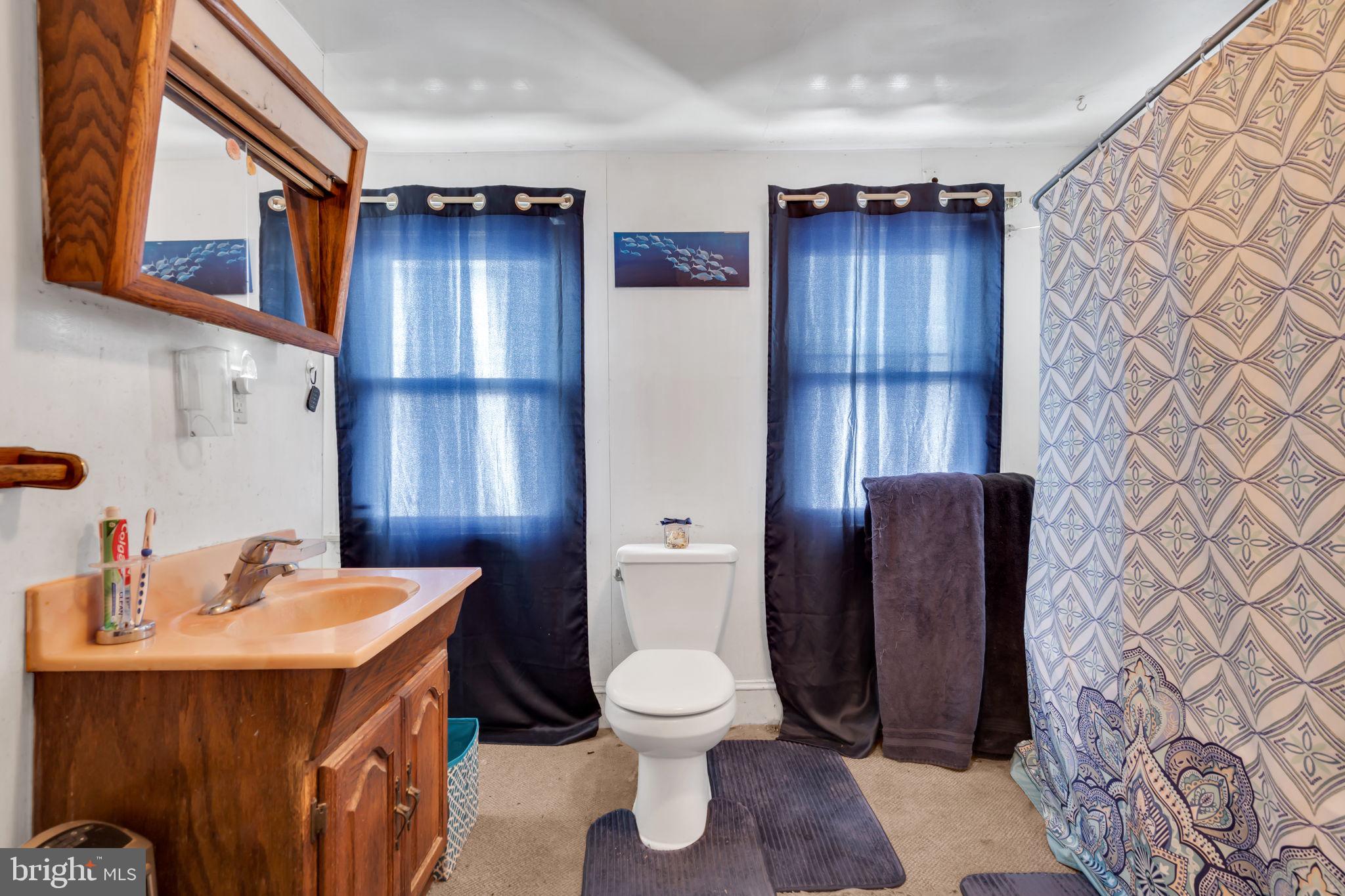 89 Chestnut Street Salem, NJ 08079 - Photo 12 of 20 a bathroom with a toilet a sink and mirror