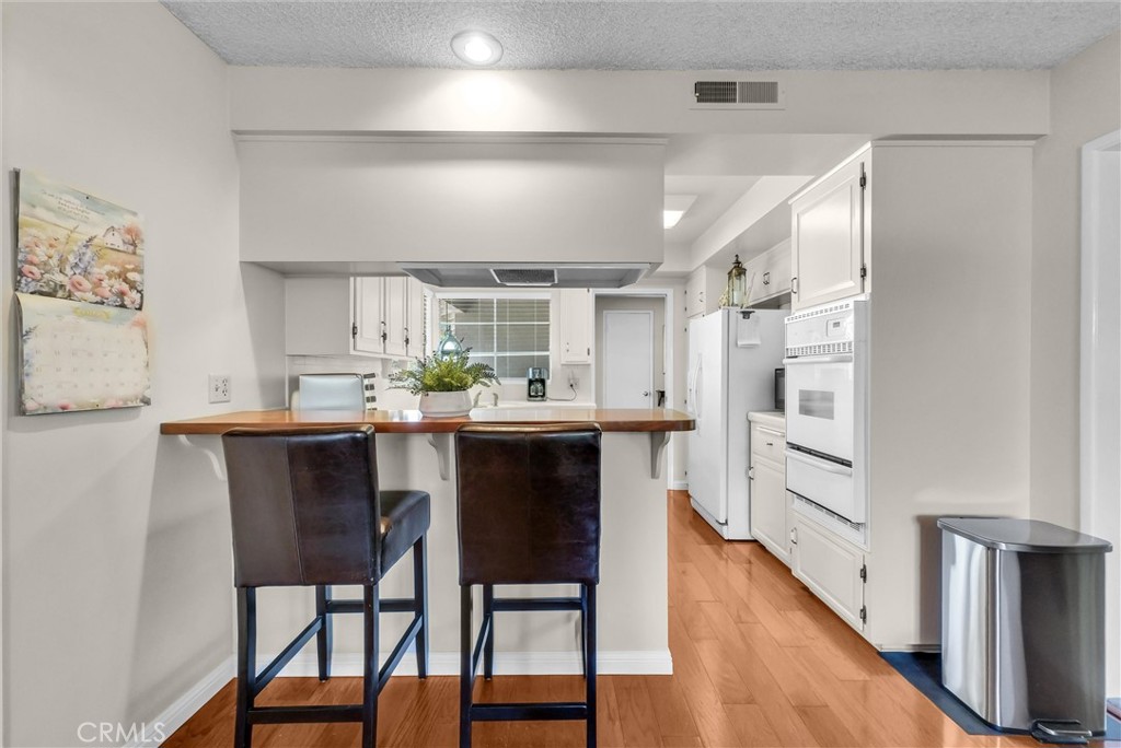 256 East Monterey Road Corona, CA 92879 - Photo 11 of 32 a kitchen with stainless steel appliances kitchen island granite countertop a table chairs and a refrigerator
