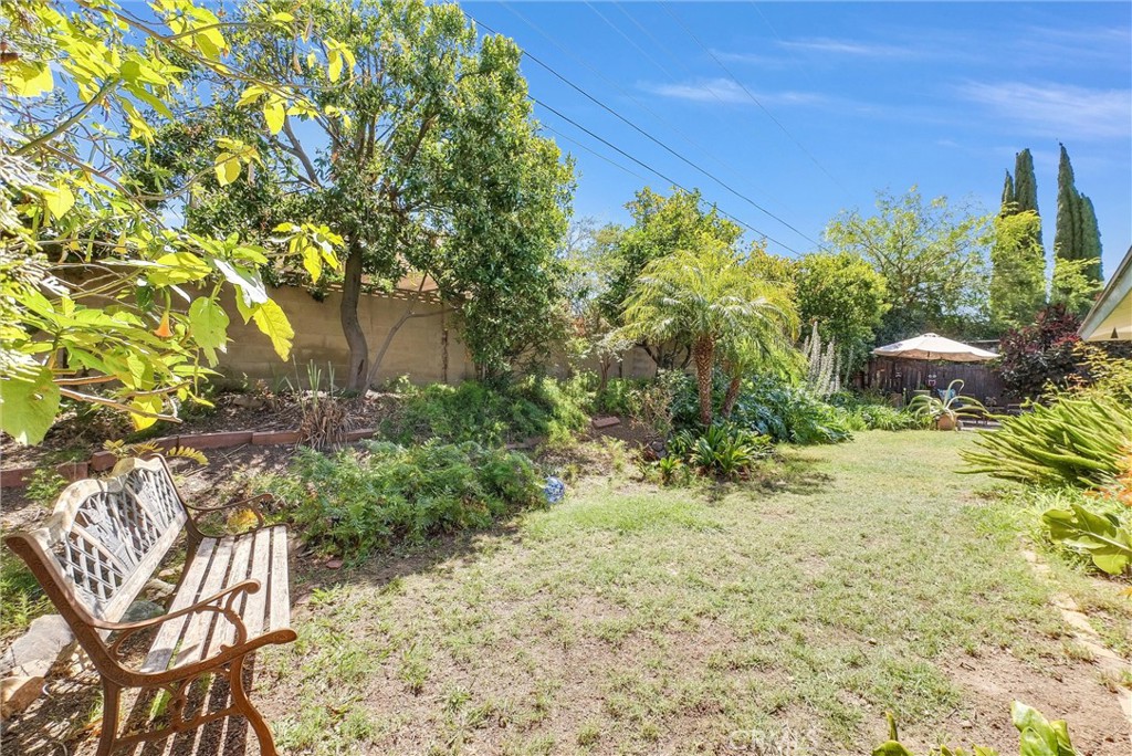 256 East Monterey Road Corona, CA 92879 - Photo 30 of 32 a backyard of a house with table and chairs under an umbrella