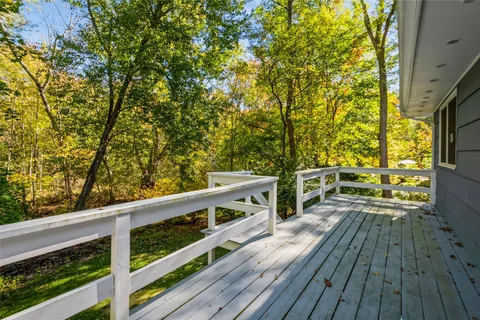 a view of balcony with wooden floor and fence