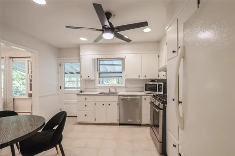a kitchen with cabinets appliances and a window