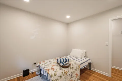 a bedroom with a bed and a wooden floor
