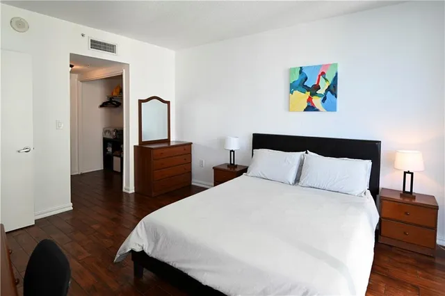 a bedroom with a bed and painting on the wall