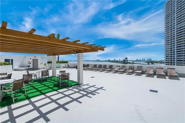 a view of a patio with table and chairs under an umbrella