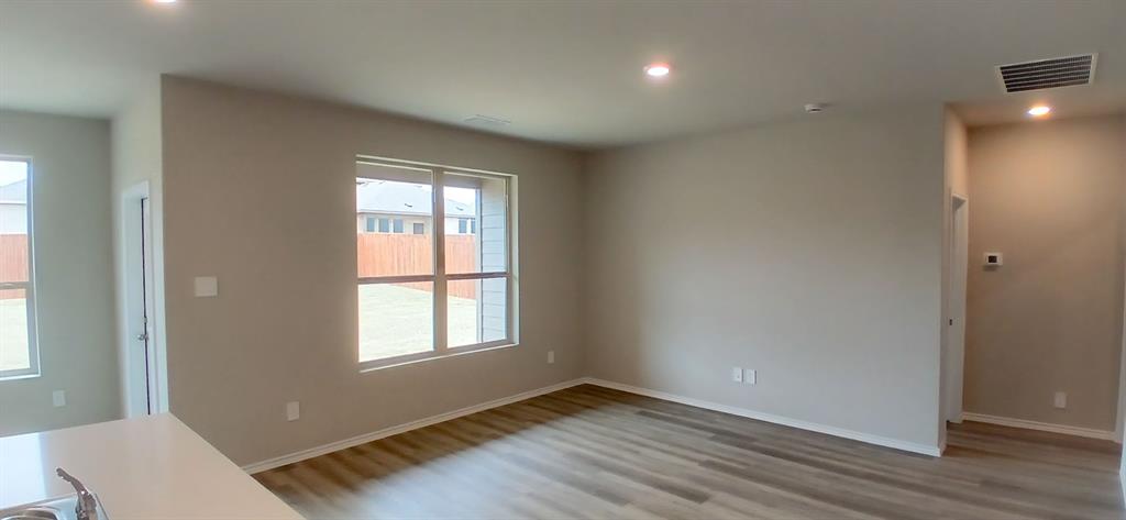 312 Perk Street Keene, TX 76059 - Photo 2 of 13 a view of an empty room with wooden floor and a window