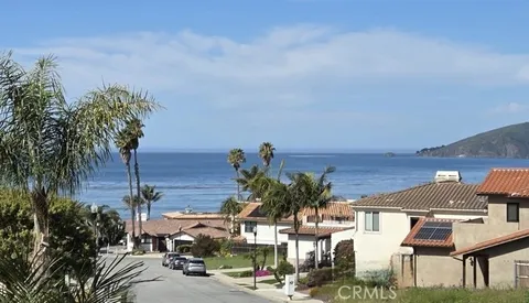 a front view of a house with a yard and mountain view