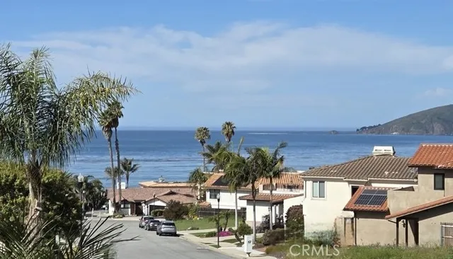a front view of a house with a yard and mountain view