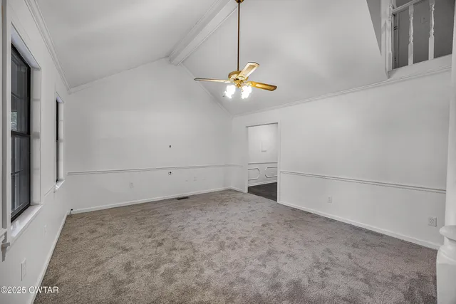 a view of a room with ceiling fan and window