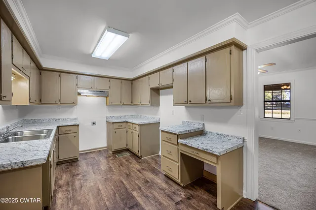 a kitchen with granite countertop stainless steel appliances a sink stove top oven and cabinets