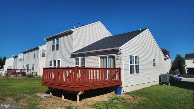 a view of a house with a wooden deck and a yard