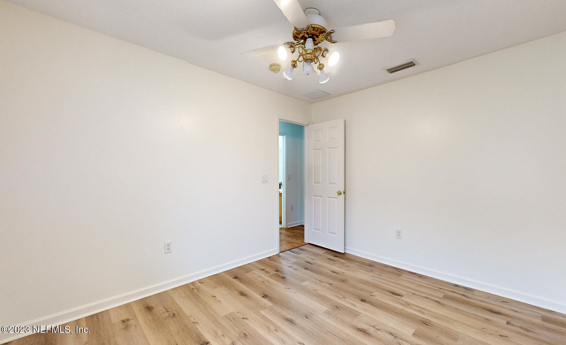 132 Summerhill Circle St. Augustine, FL 32086 - Photo 20 of 35 an empty room with a chandelier fan and wooden floor