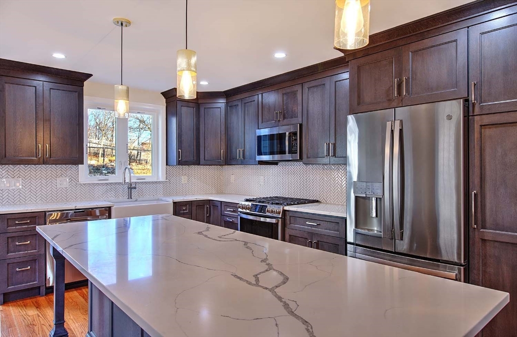 3 Wensley Street, Unit 1 Boston, MA 02120 - Photo 12 of 40 a kitchen with stainless steel appliances granite countertop a refrigerator a sink dishwasher a stove and a refrigerator with wooden floor