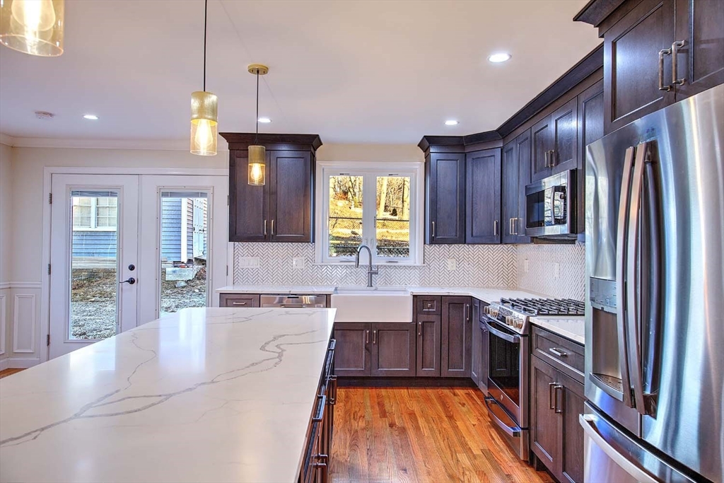 3 Wensley Street, Unit 1 Boston, MA 02120 - Photo 14 of 40 a large kitchen with stainless steel appliances granite countertop a stove refrigerator and cabinets