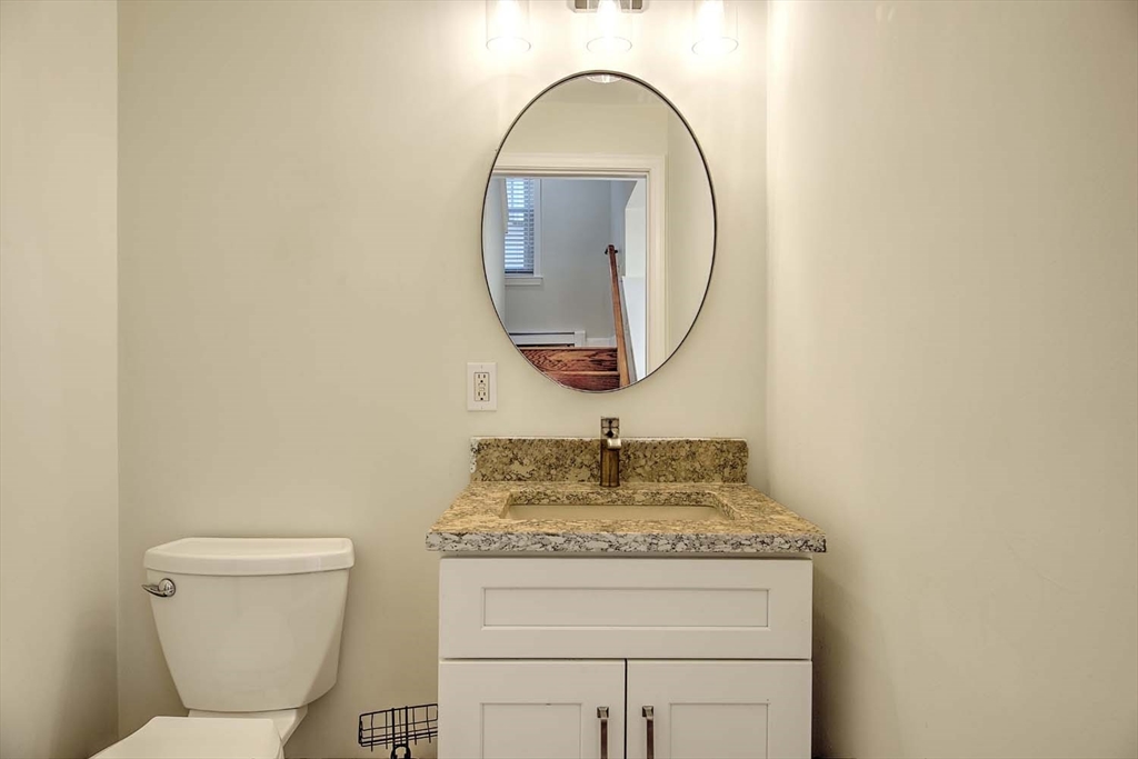 3 Wensley Street, Unit 1 Boston, MA 02120 - Photo 36 of 40 a bathroom with a granite countertop toilet a sink and a mirror