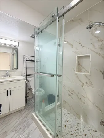 a bathroom with a shower a mirror and a sink