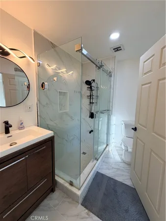 a spacious bathroom with a shower sink and mirror