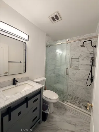 a bathroom with a granite countertop sink toilet and shower