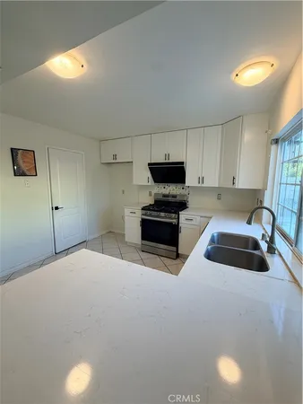 a kitchen with kitchen island a sink a stove and a microwave