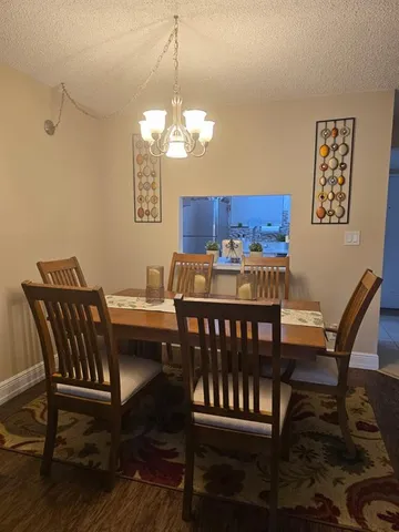 a view of a dining room with furniture wooden floor and chandelier