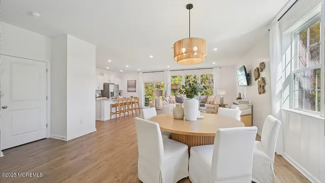 a dining room with furniture a chandelier and wooden floor