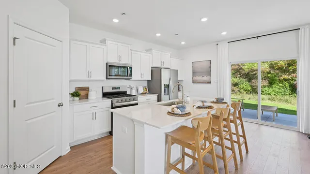 a kitchen with stainless steel appliances kitchen island granite countertop a dining table and chairs